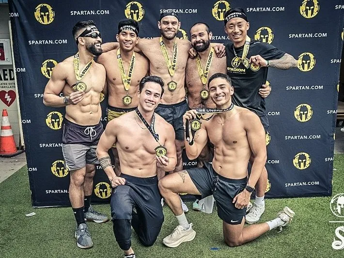 Coach Santi and his crew with their medals after finishing a Spartan race together